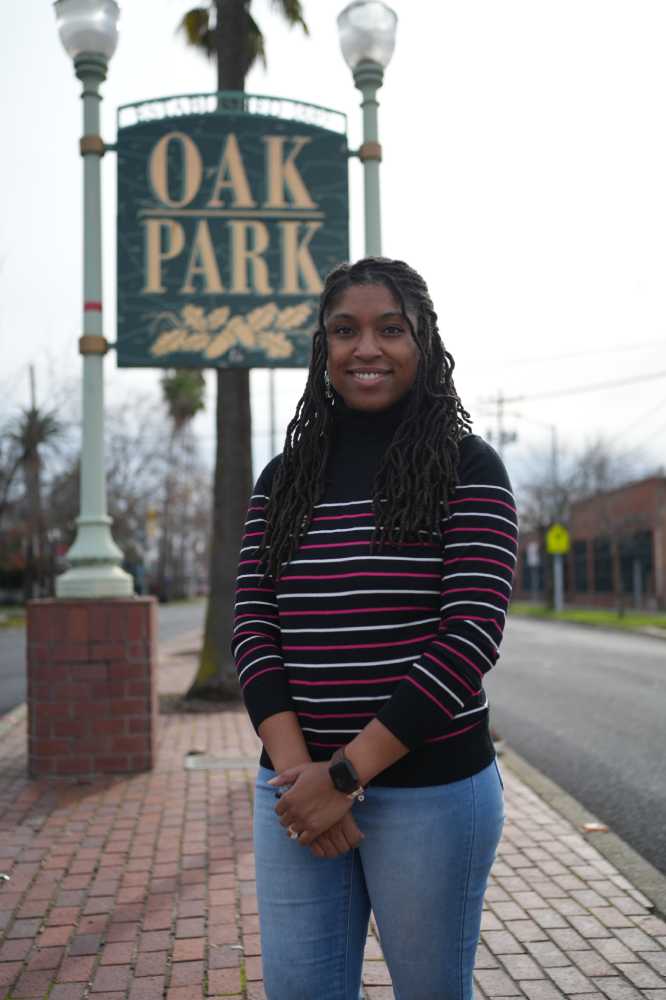Woman standing in front of Oak Park sign