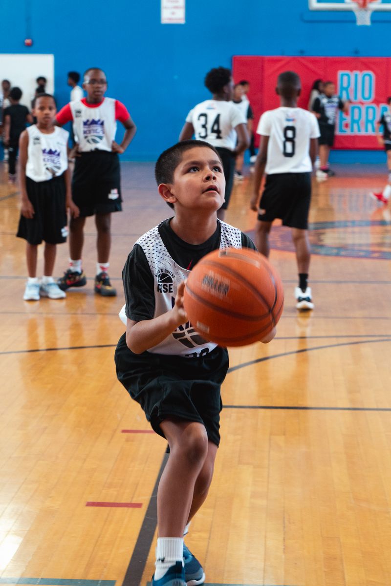 Young boy shooting a basketball at Kings and Queens Rise practice